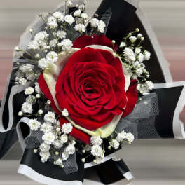 Red rose bouquet with white baby's breath and black-and-white wrapping