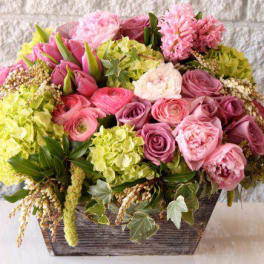Low wooden box arrangement with pink roses, peonies, and green hydrangeas