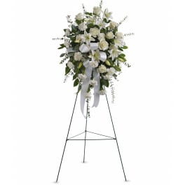 White floral standing spray on a black easel with ribbon