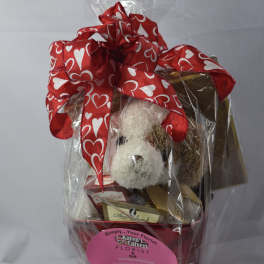 Gift basket with a teddy bear, chocolates, and a red heart ribbon