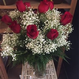 Bouquet of red roses and white baby's breath in a glass vase