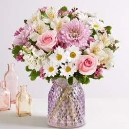 Pink and white mixed bouquet in a textured glass vase.