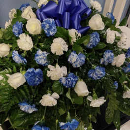 Blue and white floral arrangement with a large blue ribbon bow