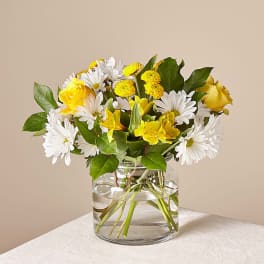 Yellow and white mixed bouquet in a clear glass vase