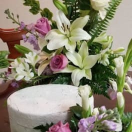 Pink roses and white lilies arranged with purple filler flowers