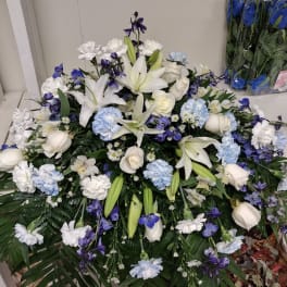 Large white and blue floral arrangement with lilies and roses