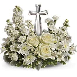 White floral arrangement with a silver cross centerpiece