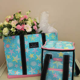 Bouquet of pink and white flowers in a patterned tote bag beside a matching cooler bag