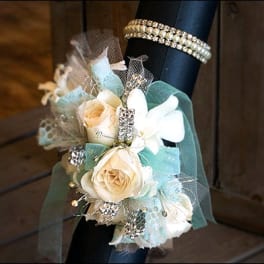 Cream rose wrist corsage with pale blue ribbon and rhinestone accents