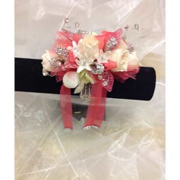 Pink and white floral corsage with ribbon and rhinestone accents