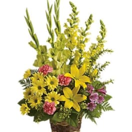 Tall yellow and pink mixed flower basket with lilies, daisies, carnations, and snapdragons