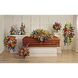 Funeral casket surrounded by bright multicolored sympathy sprays and wreaths.