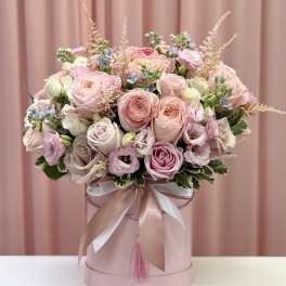 Pink and cream rose bouquet in a round hatbox with ribbon