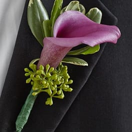 Purple calla lily boutonniere on a black suit lapel