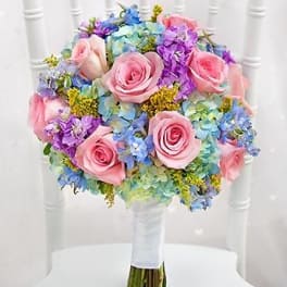 Round bouquet of pink roses and blue-purple flowers
