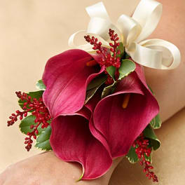 Deep pink calla lily corsage with white ribbon and red accents