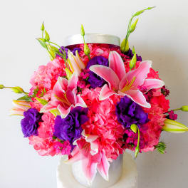 Pink lilies and purple flowers in a silver hatbox
