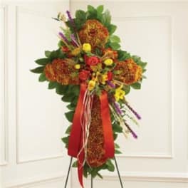 Standing floral spray with orange and yellow flowers on a red ribboned easel