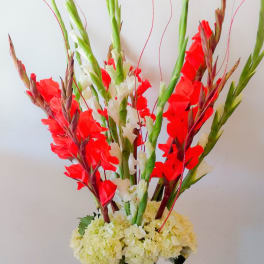 Tall red and white floral arrangement in a clear glass vase
