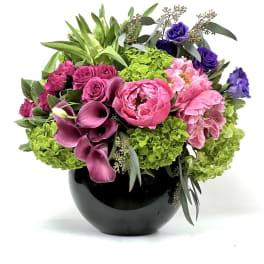 Pink and purple floral arrangement in a black vase