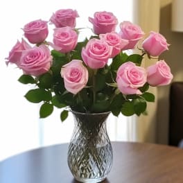 Pink roses arranged in a clear glass vase
