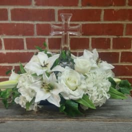 White floral arrangement with a clear glass cross centerpiece