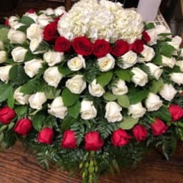 Large red and white rose arrangement with hydrangea on a table