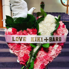 Heart-shaped pink and white carnation tribute with a white dove