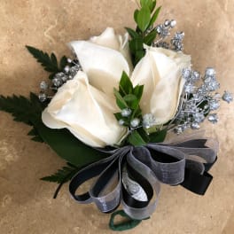 White rose boutonniere with silver filler and a black-gray ribbon