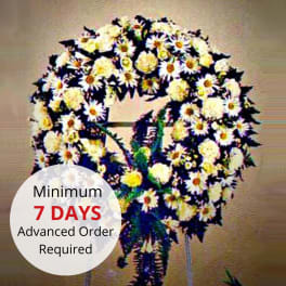 Standing circular wreath of white and yellow daisies and mums on a metal easel