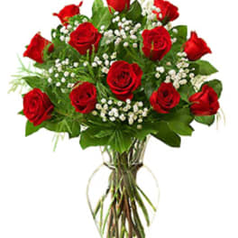 Bouquet of red roses with baby's breath in a clear glass vase