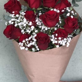 Bouquet of red roses with white baby's breath in brown paper