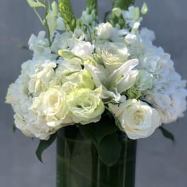 White floral arrangement in a dark glass vase