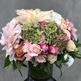 Pink and cream floral arrangement in a dark vase