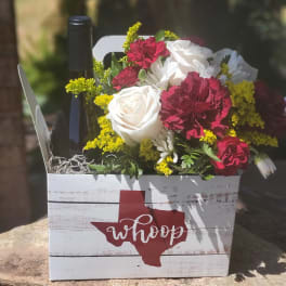 Flowers and a wine bottle in a white wooden gift box