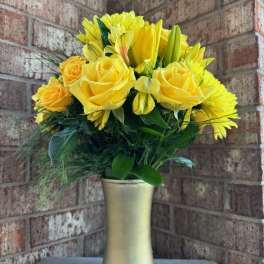 Yellow roses and lilies in a gold vase