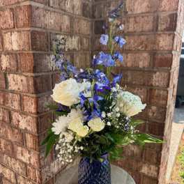 Blue and white floral arrangement in a cobalt vase