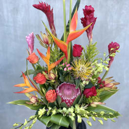 Tropical bouquet with red ginger, orange heliconia, roses, and orchids in a vase