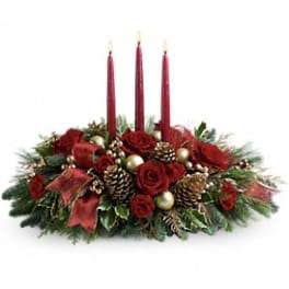 Holiday centerpiece with red roses, pinecones, and three red taper candles