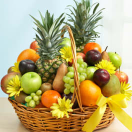 Fruit basket with pineapples, grapes, apples, oranges, pears, and yellow flowers