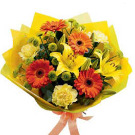 Bouquet of orange gerbera daisies and yellow lilies wrapped in yellow paper