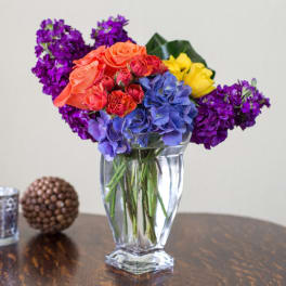 Colorful bouquet of roses and hydrangeas in a clear glass vase