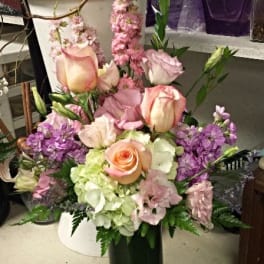 Pink and lavender floral arrangement in a green vase