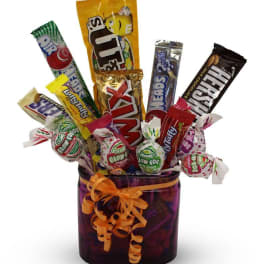 Candy bouquet in a purple vase with assorted chocolate bars and lollipops