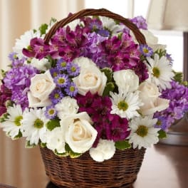 Basket of white roses, purple flowers, and white daisies