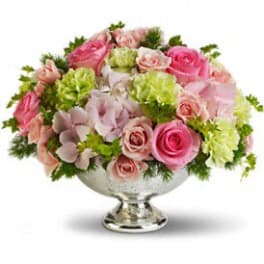 Pink roses and pale blooms arranged in a silver pedestal bowl