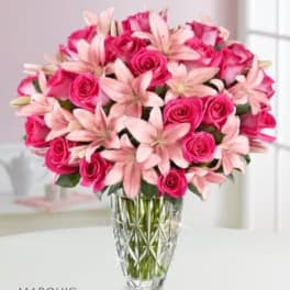 Pink roses and pale lilies in a clear glass vase