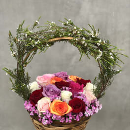 Basket of multicolored roses with a curved floral handle
