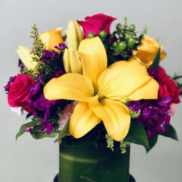 Bouquet of yellow lilies and pink roses in a green vase
