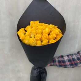 Bouquet of yellow roses wrapped in black paper
